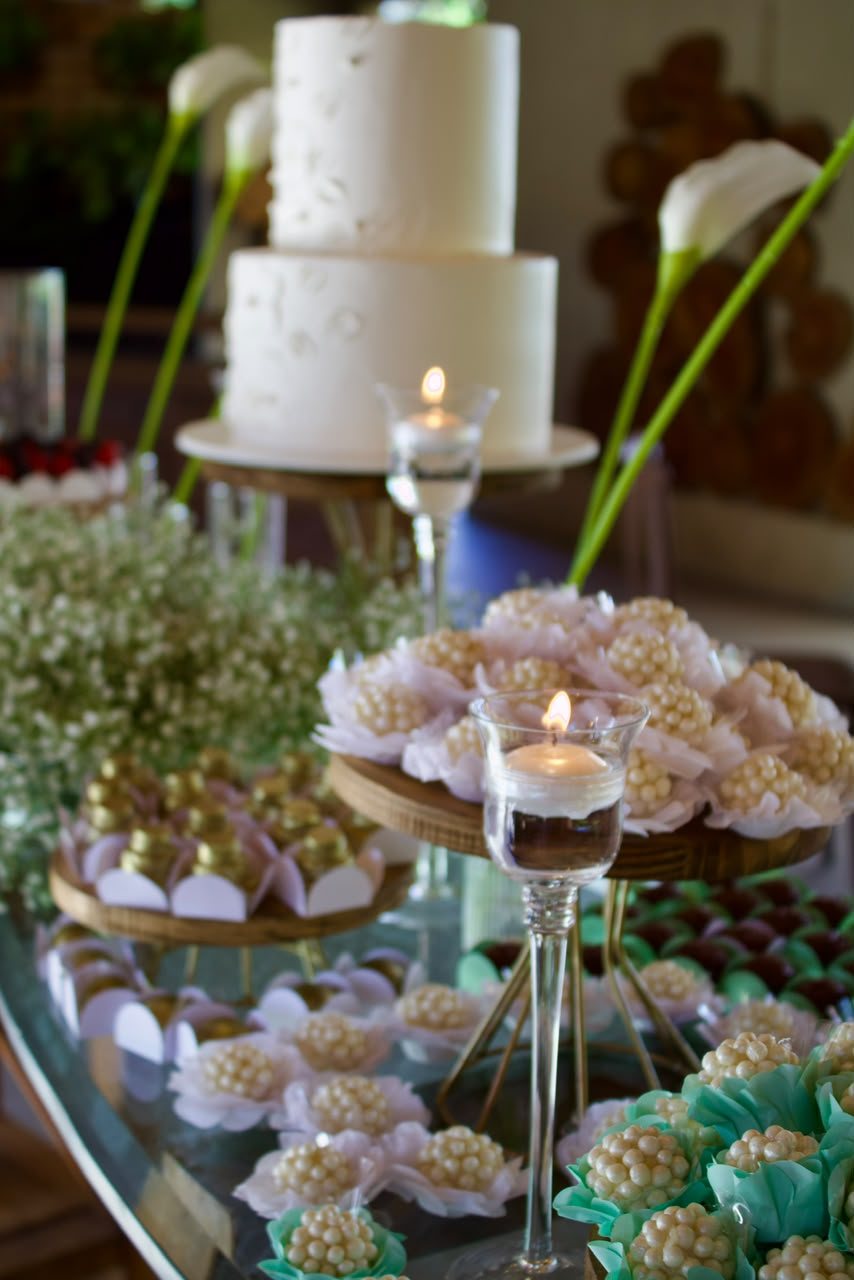 Mesa de doces em espelho — Doces finos sobre bandejas espelhadas, com velas e detalhes em verde água.