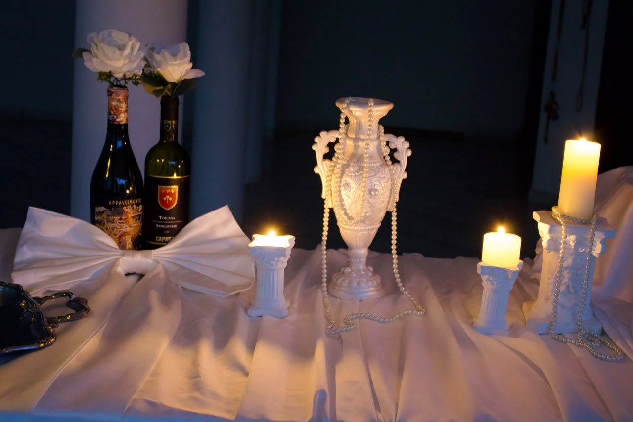 Objetos do acervo: ânfora de porcelana, pérolas, colunas de gesso, velas e garrafas laçadas em tule